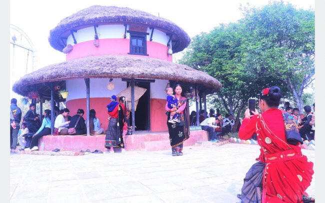 घुमाउने घरलाई पृष्ठभूमिमा पारेर तस्बिर खिचाउँदै आन्तरिक पर्यटक