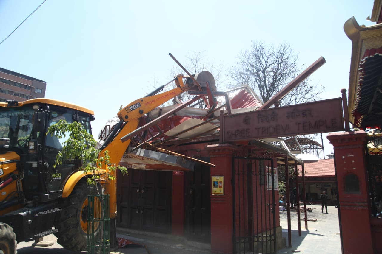 काठमाडाैं महानगरले चलायाे त्रिदेवी मन्दिरमा बनेको अनाधिकृत संरचनामा डाेजर (तस्विर)